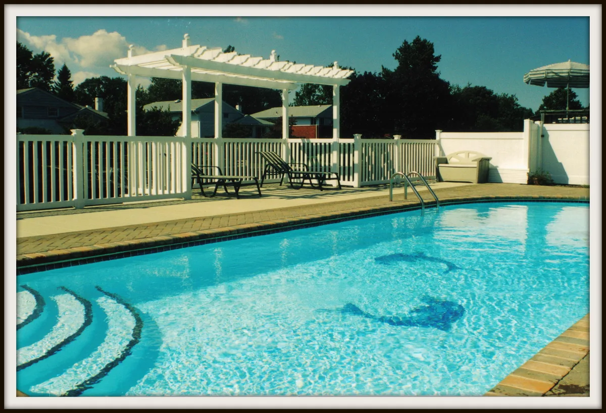 Poolside view with white PVC fence and pergola showcasing Schiano Fence craftsmanship