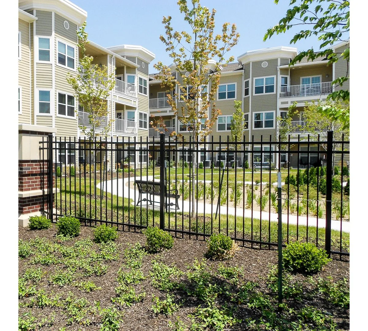 Black aluminum fence at residential complex with landscaping