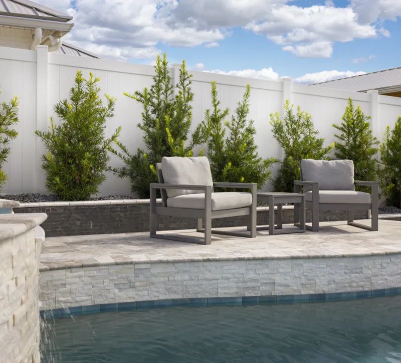 White PVC privacy fence with poolside patio seating